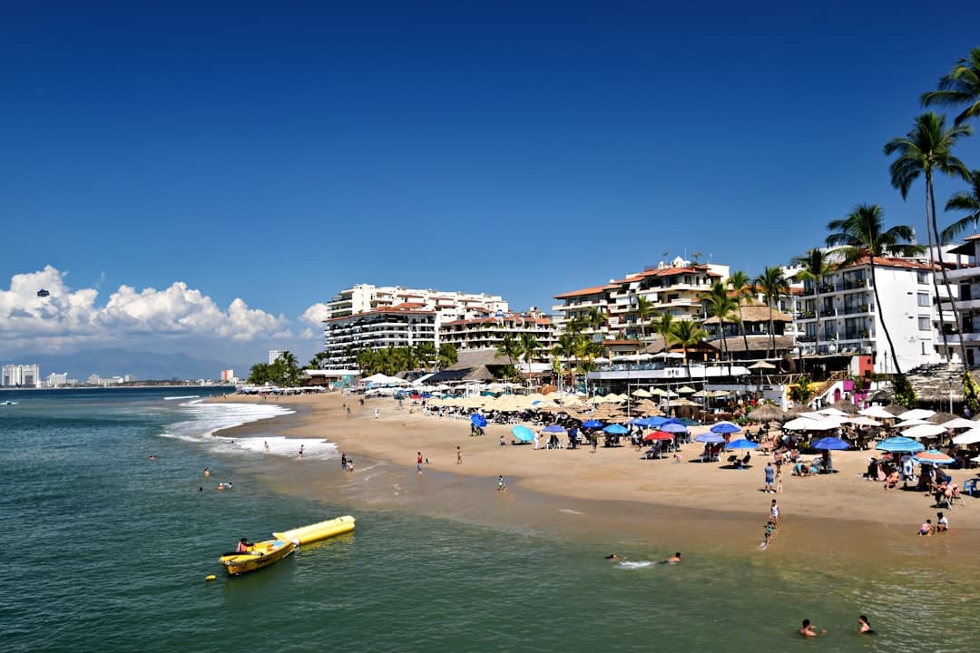 People relax on a sunny beach with ocean waves.