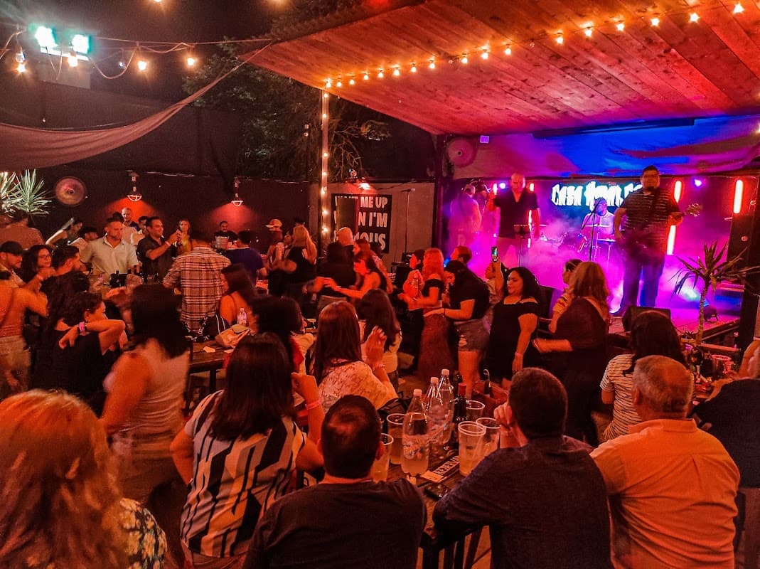 Exterior iluminado de Restaurante Los Sillares con su letrero y una mesa llena de tacos al carbón