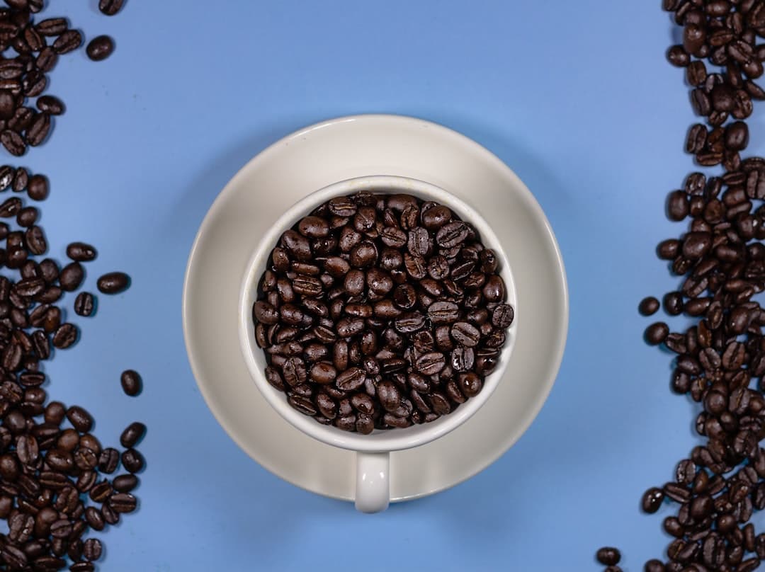a cup of coffee surrounded by coffee beans