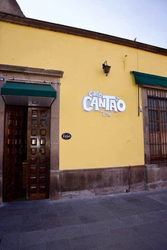 Fachada azul del Café Canta'o de Alfredo con su letrero visible, gente esperando en la calle
