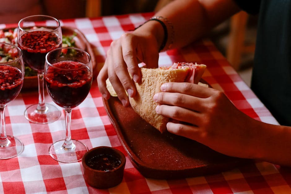 A cozy dining scene with a sandwich and wine on a checkered tablecloth in Mexico.