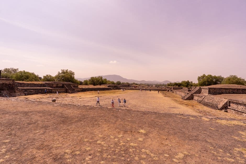 A stunning wide-angle view of the ancient Teotihuacan site, showcasing historical ruins under a clear sky.