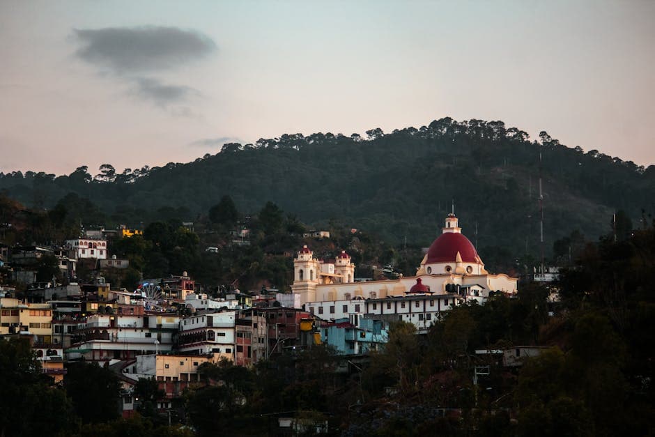 Scenic view of the Basilica of Our Lady of Juquila surrounded by lush hills in Oaxaca, Mexico.