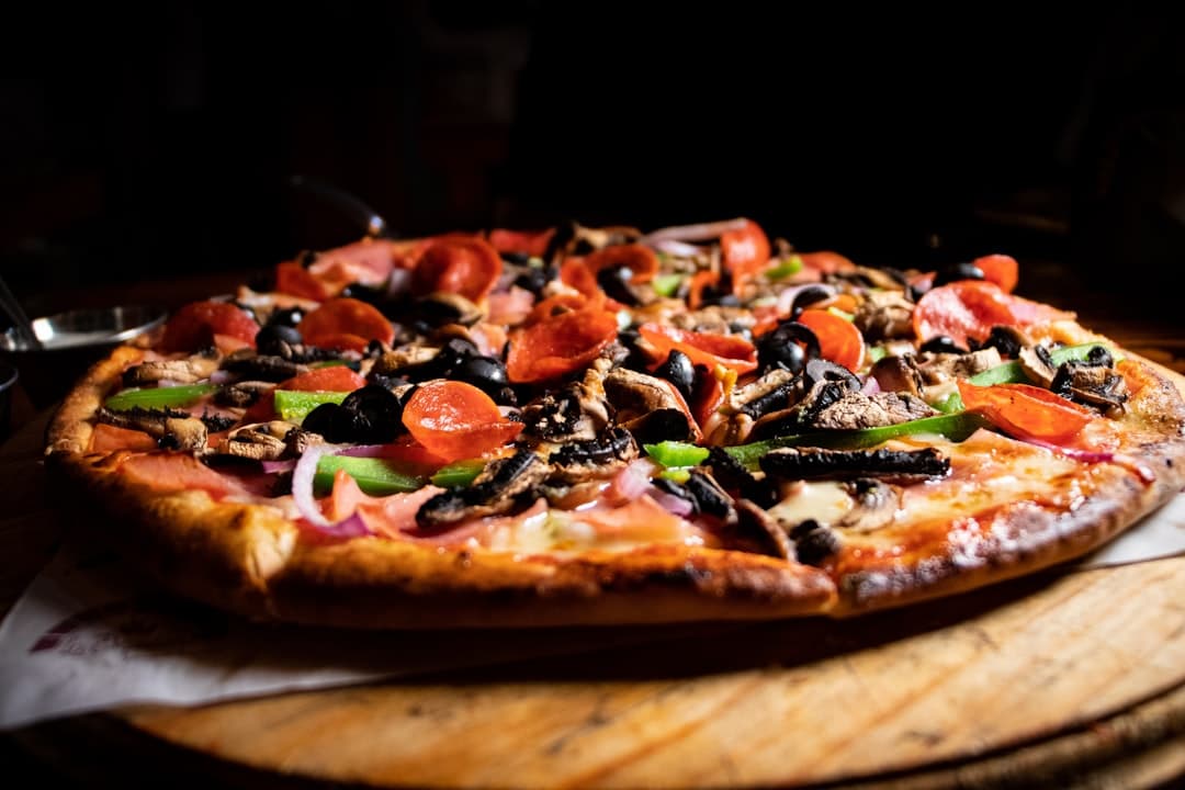 a pizza sitting on top of a wooden cutting board