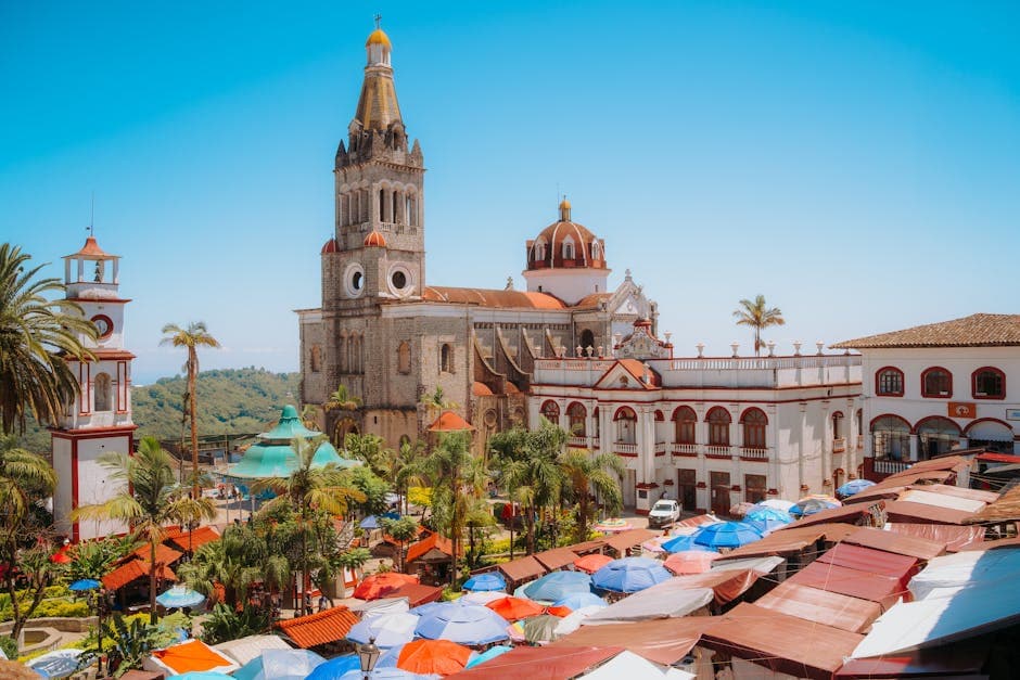 Colorful market day with historic church in Cuetzalan, Mexico under clear sky.