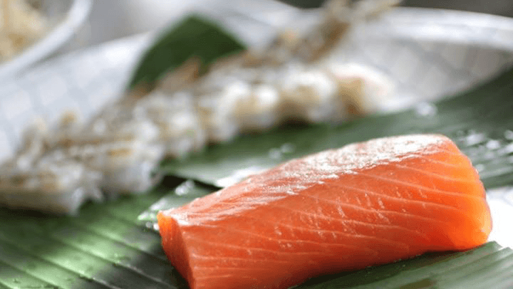 Vista del interior de Sawa Sushi Tijuana con barra de sushi y platos de nigiri sobre una mesa de madera