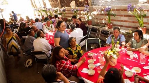 Exterior colorida de MO‑KALLI Restaurante con su letrero de madera y una mesa con mole humeante al frente