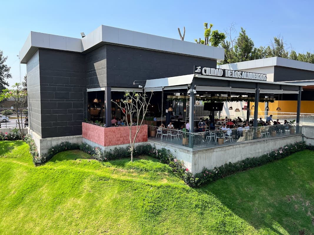 Terraza de City of Brunch con mesas al aire libre, mostrando un plato de chilaquiles y jugo fresco
