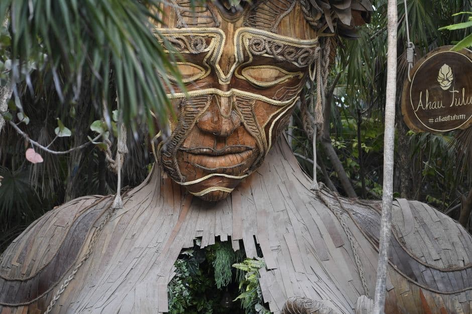 Discover the majestic Ven a La Luz wooden sculpture in Tulum's lush jungle setting.