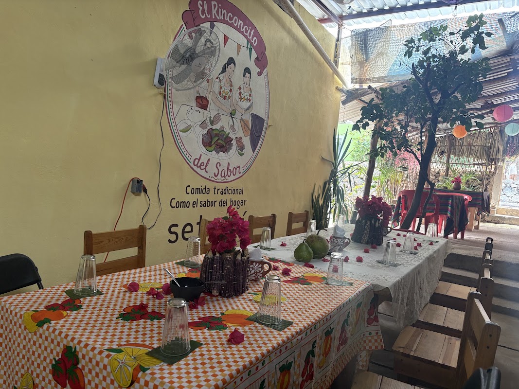 Exterior de El Rinconcito Del Sabor con su letrero colorido y mesas al aire libre — captura la atmósfera matutina