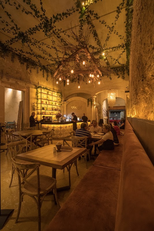 Interior de Ragazzi Bistro con mesas de madera, focos colgantes y clientes disfrutando la cena — ambiente nocturno