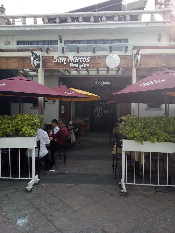Taco al pastor y pantalla de fútbol en Merendero San Marcos, ambiente de terraza con luces colgantes