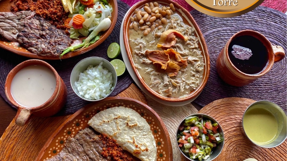 Tazón de pozole con maíz y chicharrón en Cenaduría San Antonio, acompañado de cilantro y limón