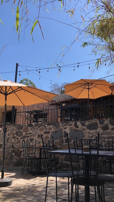 Las Grutas Amatitán — vista de la pizza artesanal en horno de leña y la barra de mixología con cócteles coloridos