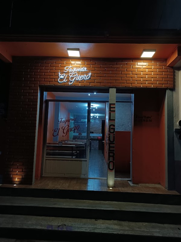 Fachada de Taqueria El güero en Calle 5 Pte. 26, con tacos en una tabla y el letrero del local.