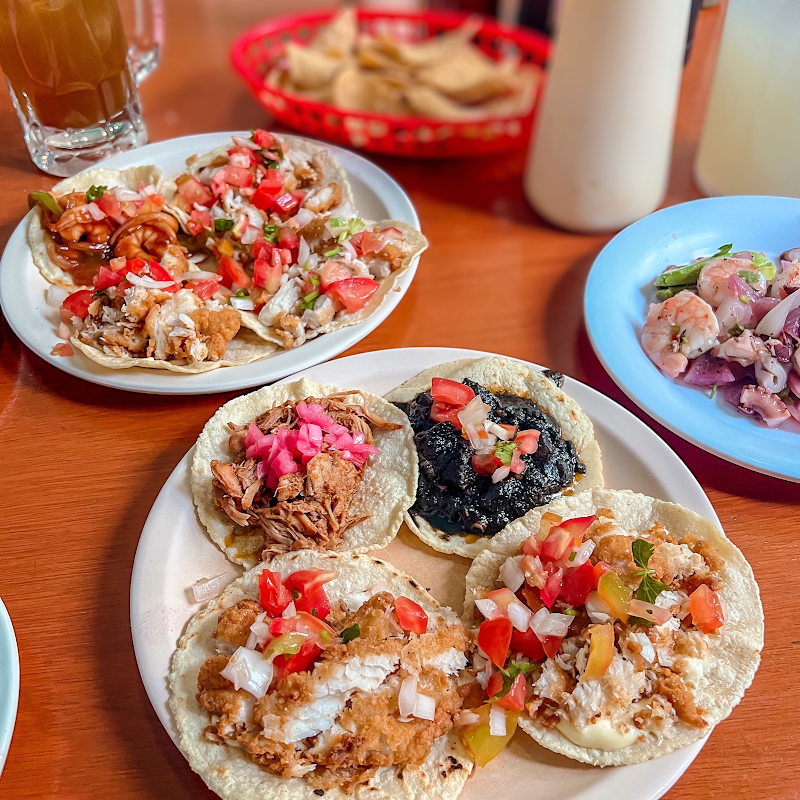 Los de Atlixco — fachada de calle en el Centro, un burrito al pastor con guacamole y una jarra de agua de maracuyá sobre el mostrador