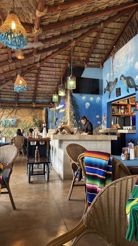 Las Mariscadas – snapper a la parrilla con piel dorada, escenario con músicos en vivo