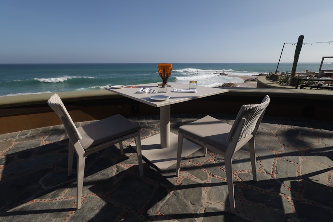 a table and chairs on a patio overlooking the ocean