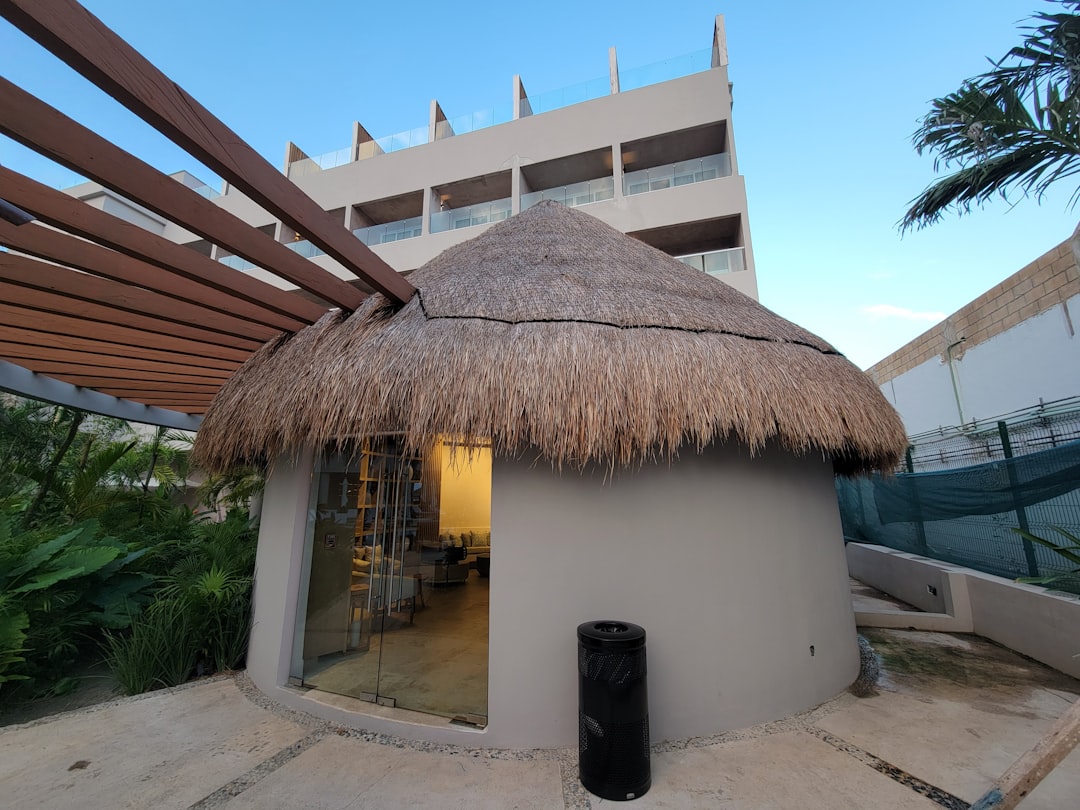 A small hut with a thatched roof on a patio