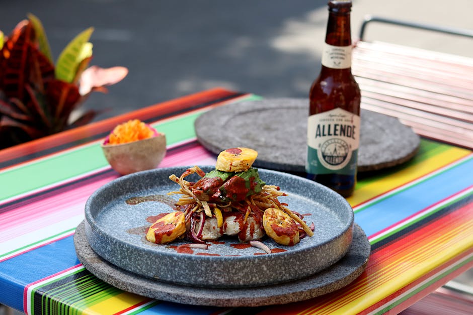 Delicious gourmet meal on a colorful table setting with a bottle of Allende beer.