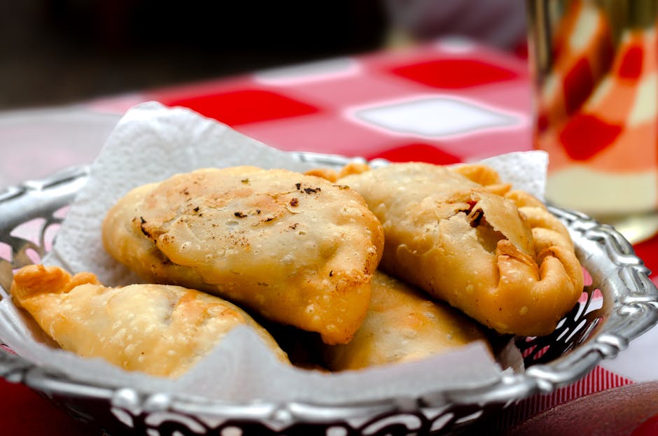 Close-up of freshly baked Argentine empanadas on a decorative plate, perfect for food lovers.