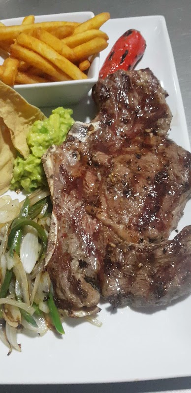 Plato de chiles en nogada en Las Margaritas, mostrando la salsa y la granada — primer plano