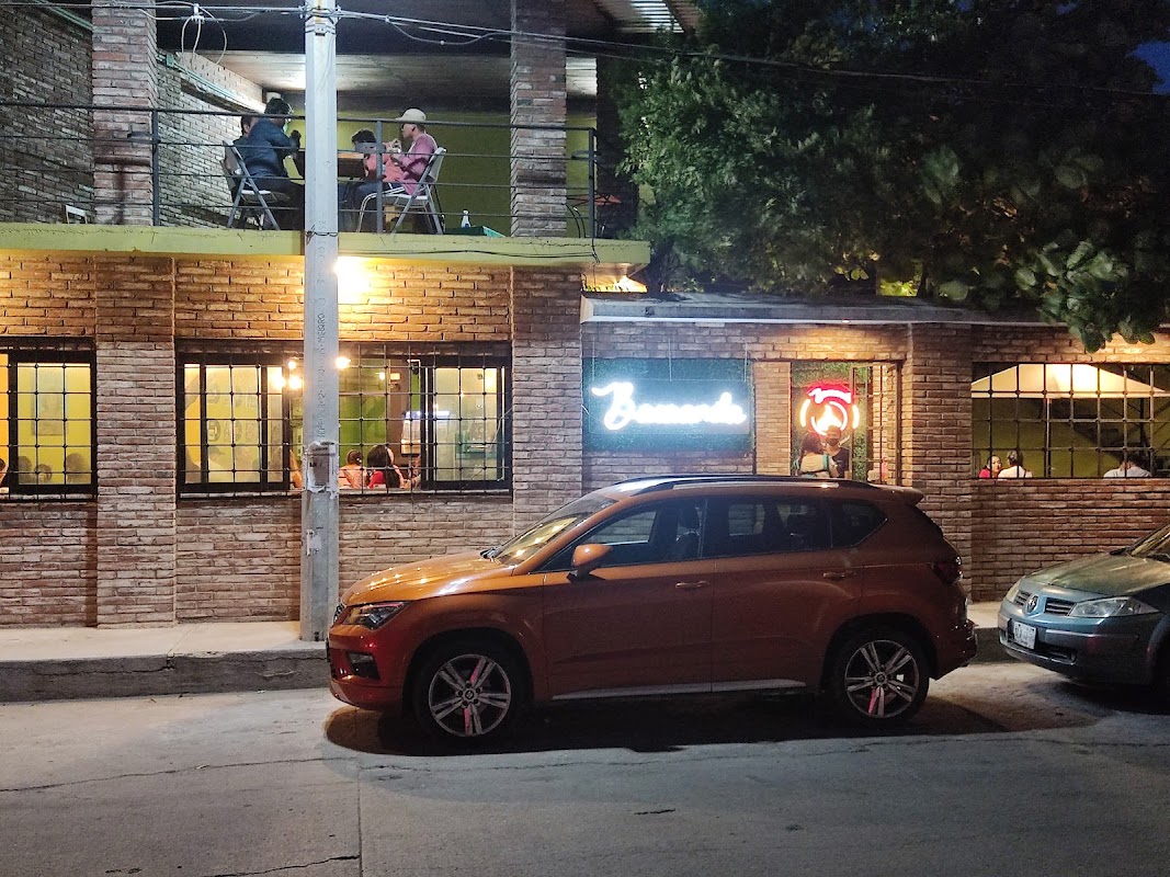 Exterior del Café Bacaanda con su fachada de ladrillo y mesas al aire libre, mostrando waffles y crepes en una mesa cercana