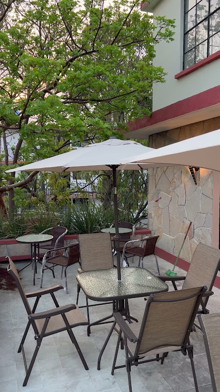 Interior del bar mostrando el mostrador de mármol, un cóctel de mezcal ahumado y un tazón de caldo de camarón en El Lobo Marino