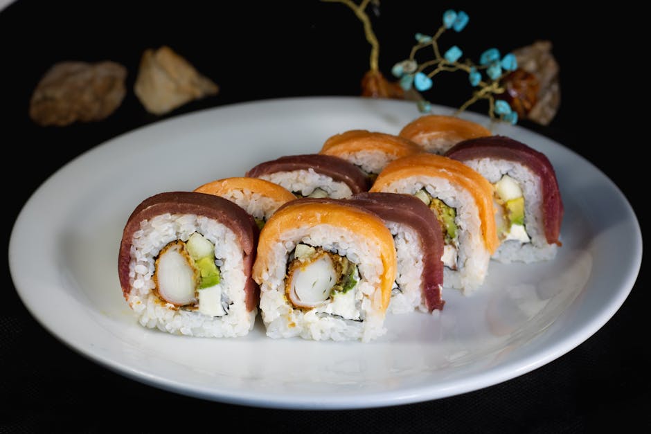 Colorful sushi rolls with fresh fish and avocado, served on a white plate. Perfect for food lovers.