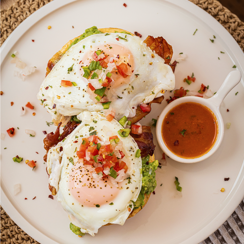 Dolce Bisquet - VIA CORDILLERA con un plato de chilaquiles rojos y una copa de jugo de naranja al lado