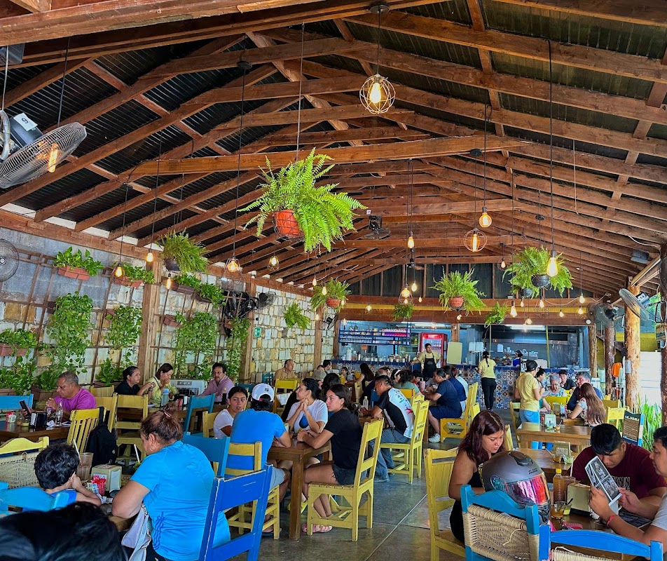 Laca Laca Restaurante ambiente nocturno, mesas llenas y platos de chicharrón de queso bajo luz tenue