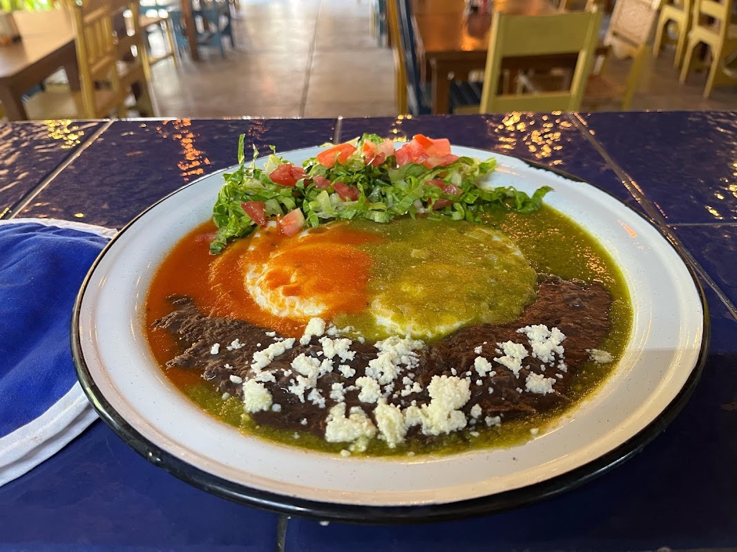 Desayuno de bocol con guisada en Artesano, plato humeante acompañado de una taza de café