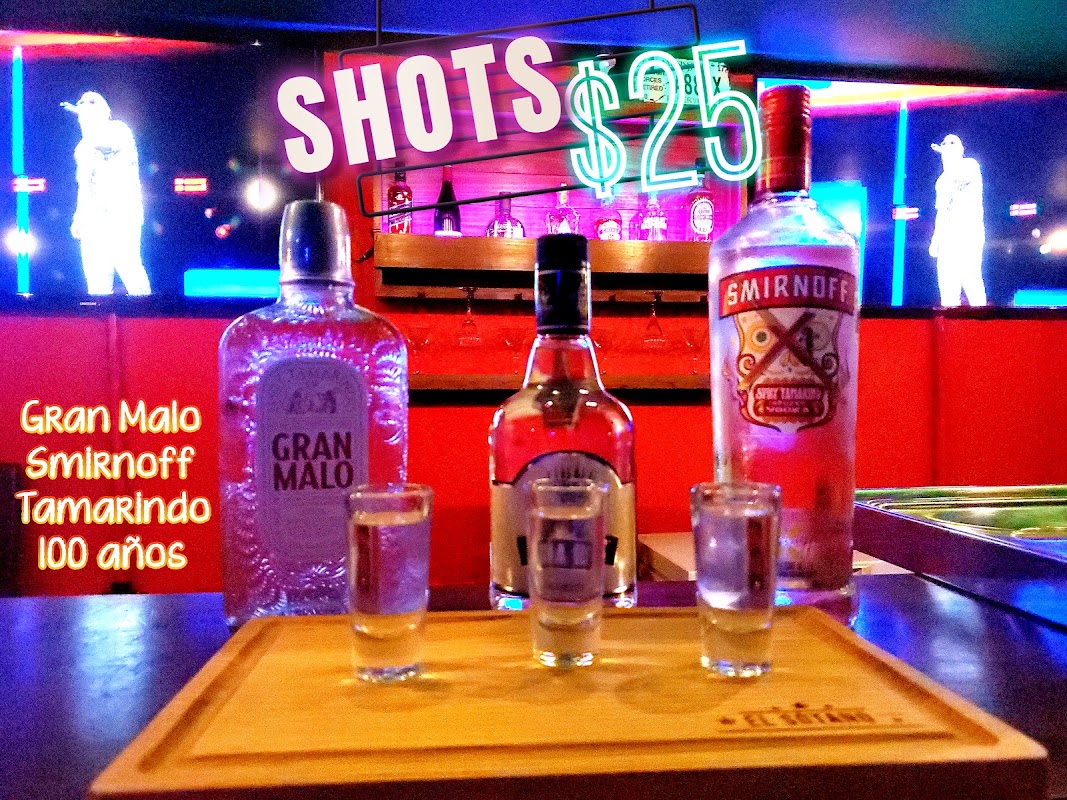 El Sótano – barra del pub con luces tenues, cervezas artesanales y una hamburguesa jugosa sobre la tabla de madera