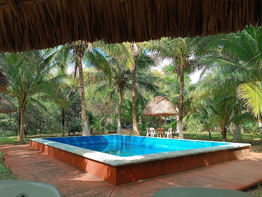 Patio de Restaurante El Ranchito con piscina al fondo y una tabla de tacos y cerveza fría