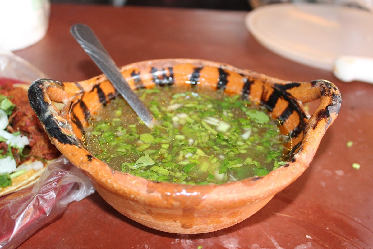 Taco de barbacoa y tazón de consomé en Barbacoa Don Chava — foto del taco y el caldo humeante