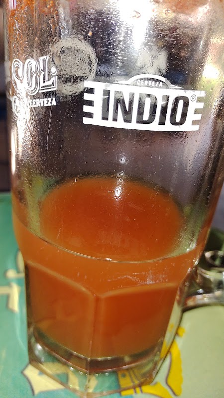 Bar de EL JARDÍN con vasos de michelada, luces de neón y camarones al ajillo en la barra