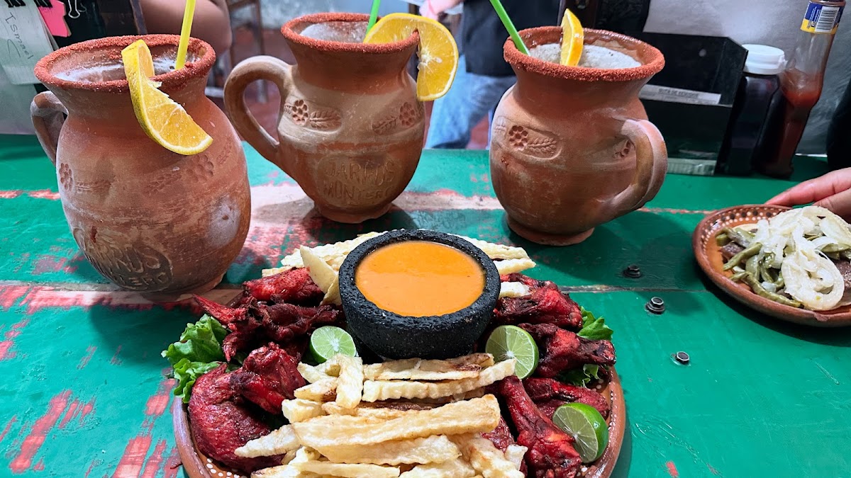 Bar area of Restaurante Jarros Montero with a frothy michelada in a jar and a plate of gorditas de chicharrón
