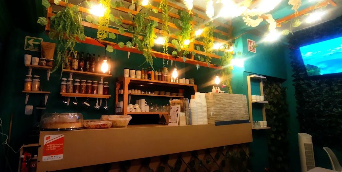 Escenario de ¡Ajá! Rock Café con una guitarra eléctrica y clientes tomando café mocha