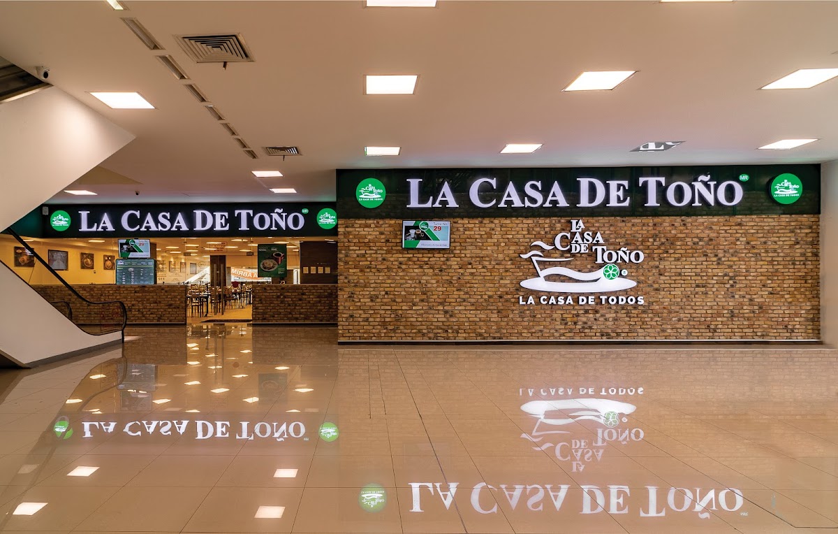 Exterior colorido de La Casa de Toño en Plaza Chimalhuacán con clientes en fila y el letrero tradicional