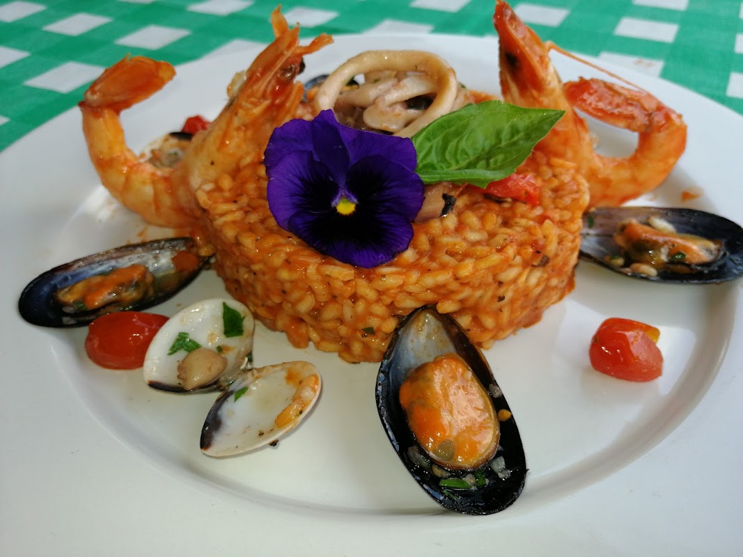Primer plano del risotto de camarones en un cuenco hondo, mostrando la cremosidad y los camarones brillantes