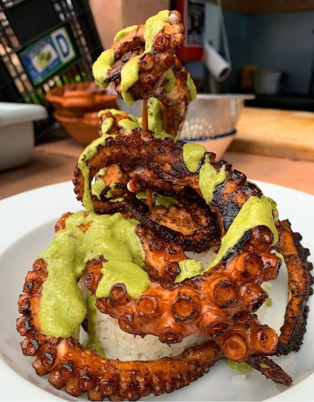 Plato de pulpo a la parrilla con salsa de chile guajillo en Pescados y Mariscos Tío Froy — primer plano del marisco y la salsa