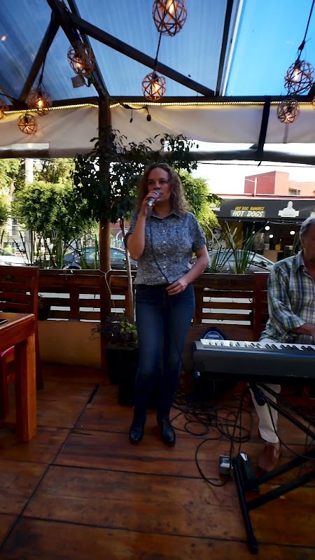 Interior de Sapore d Italia mostrando mesas de madera, luces cálidas y el chef trabajando en la cocina abierta
