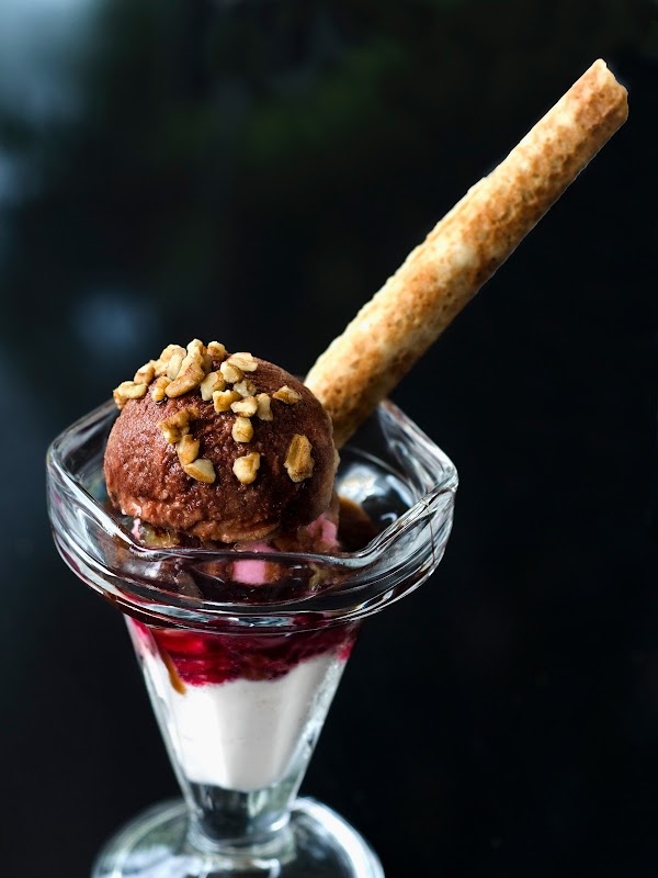 Cucharada de nieve de mandarina en un cono crujiente en Nevería Roxy — primer plano del helado brillante
