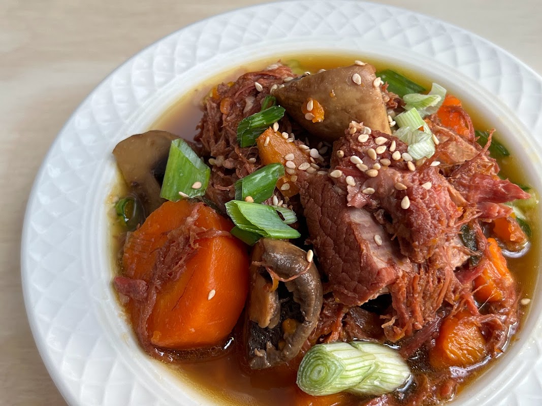 Primer plano del estofado de ternera con kimchi servido en olla de barro en OPPA 오빠 — detalle del caldo humeante y los vegetales