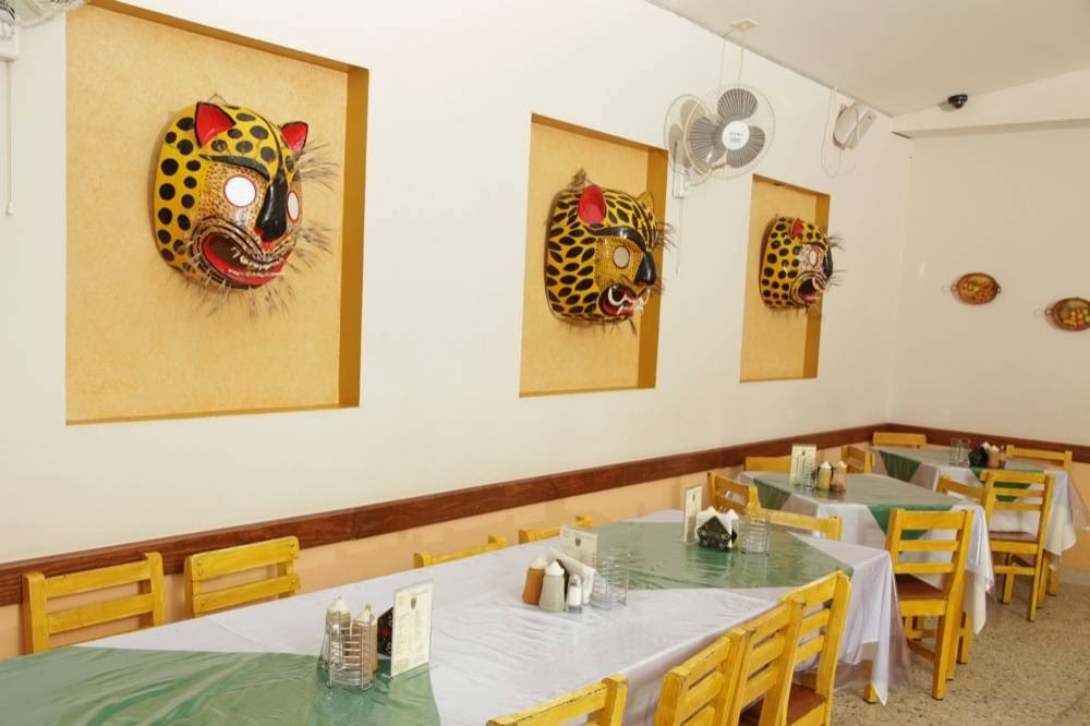 Interior de Casa Licha Pozole: mesas de madera, barra de hierro y menú en pizarra