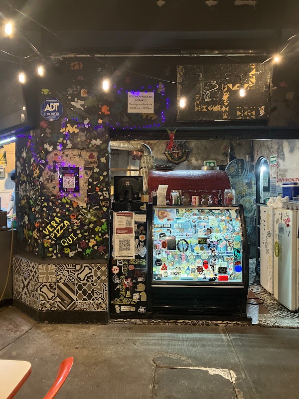 Interior de Pizzaexpress con barra de madera, horno de leña visible y ambiente relajado con mesas ocupadas
