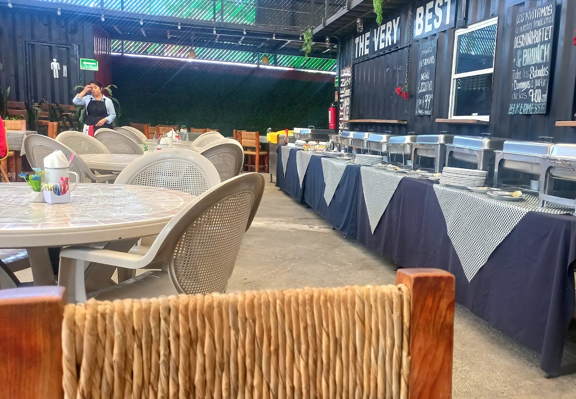 Cocina abierta de La Kermesse con chef moviendo la paellera y vapores aromáticos