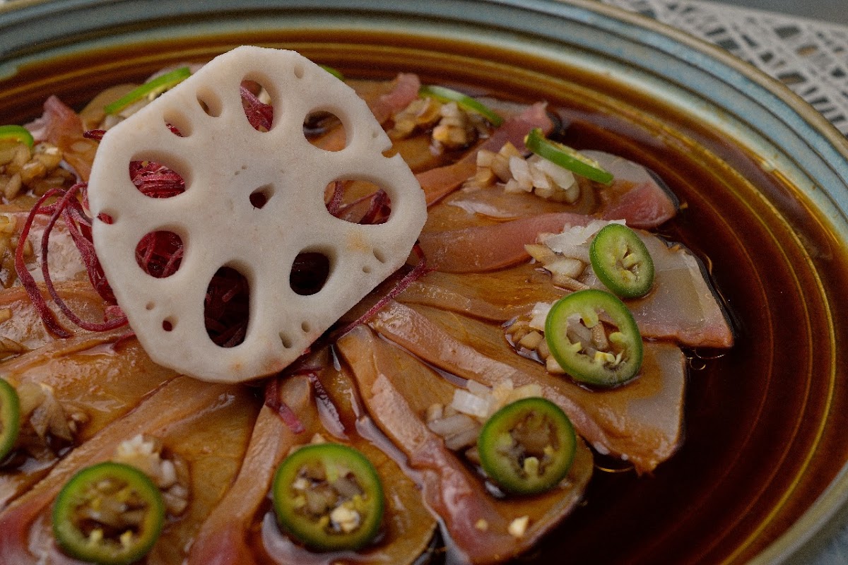 Primer plano del nigiri de anguila en ABURIYA BY SHIGE TAKANE — pescado brillante sobre arroz, salsa de soja al fondo