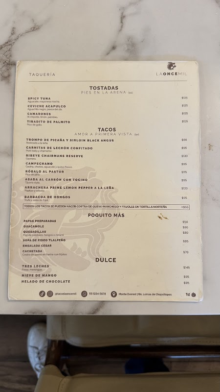 Interior de La Once Mil, barra de tacos y chefs trabajando al fuego