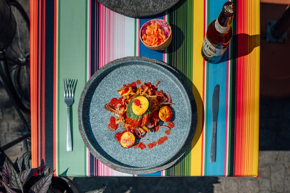 Vibrant Mexican dining experience featuring a plated meal and craft beer on a colorful table setting.